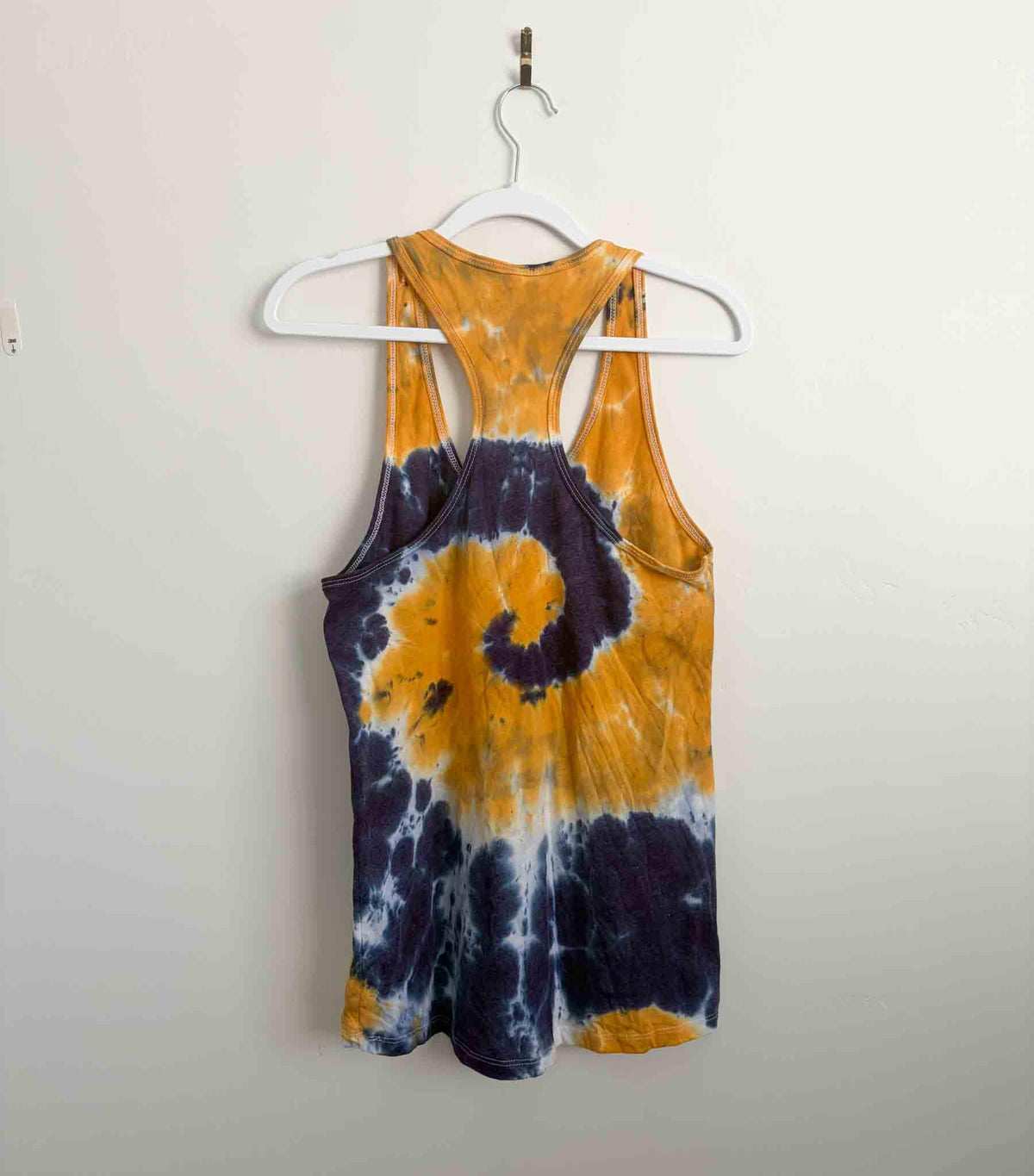 Back view of mustard yellow and navy purple spiral tie dye racerback tank top