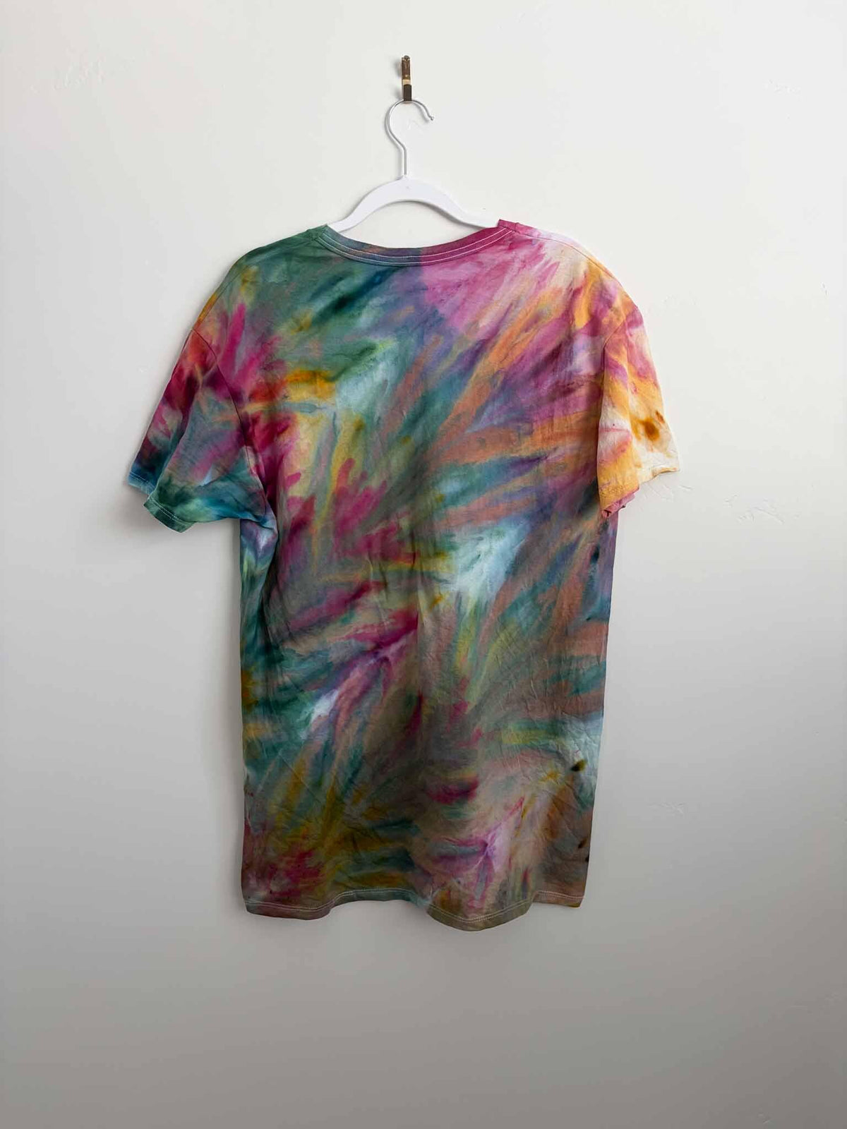 Rainbow ice dye fern fold v-neck shirt back view on hanger tie dye pattern
