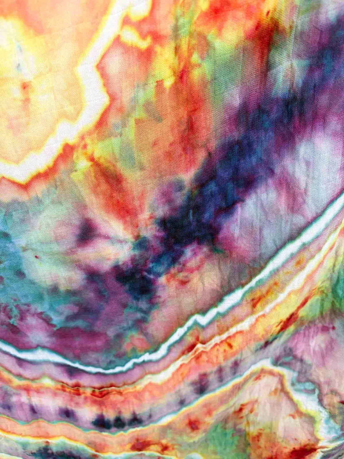 Detail shot of white crystal veining in geode tie dye pattern on bamboo gauze baby swaddle blanket