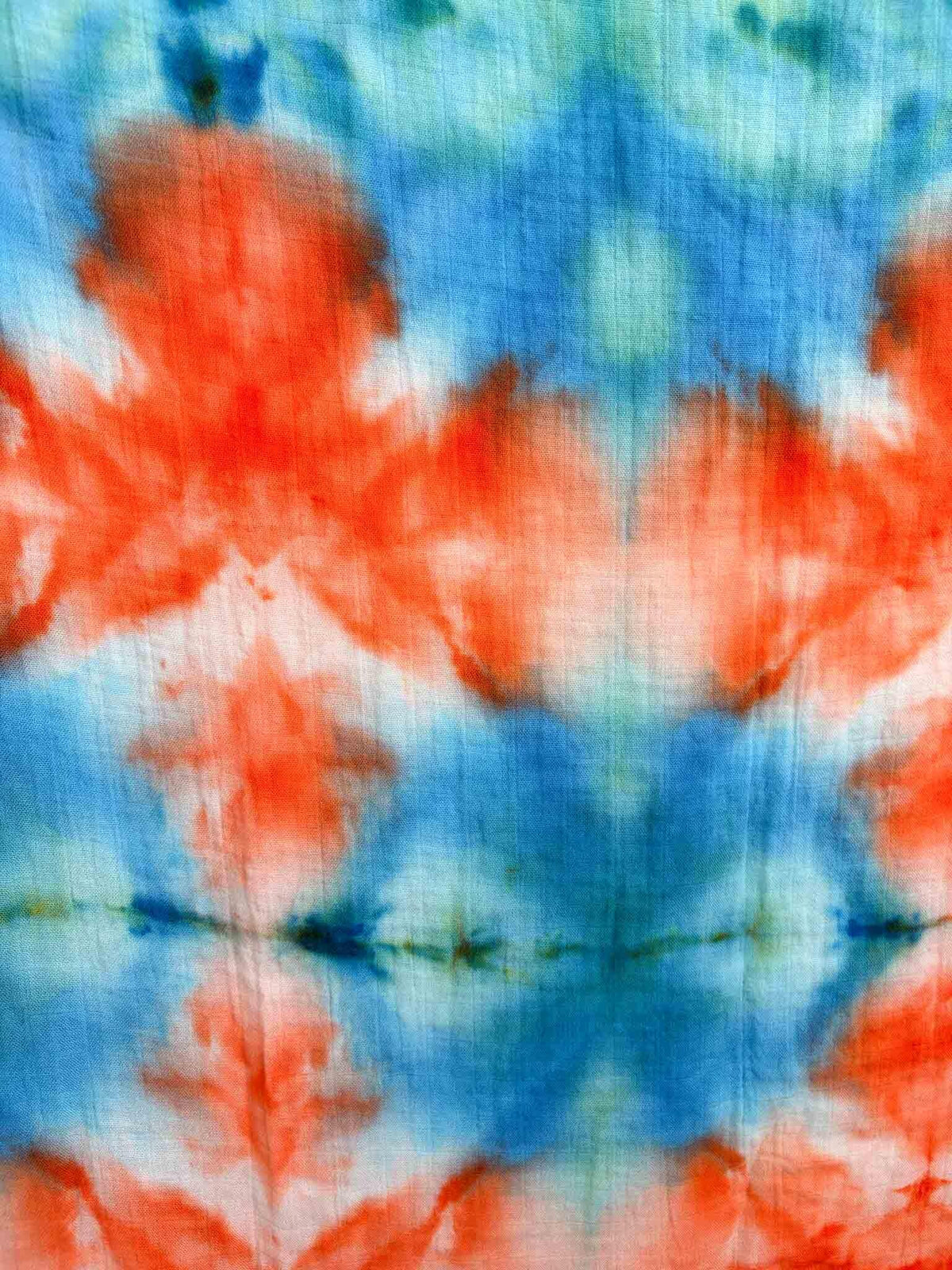 Detail shot of orange and teal diamond tie dye pattern on bamboo gauze baby swaddle blanket