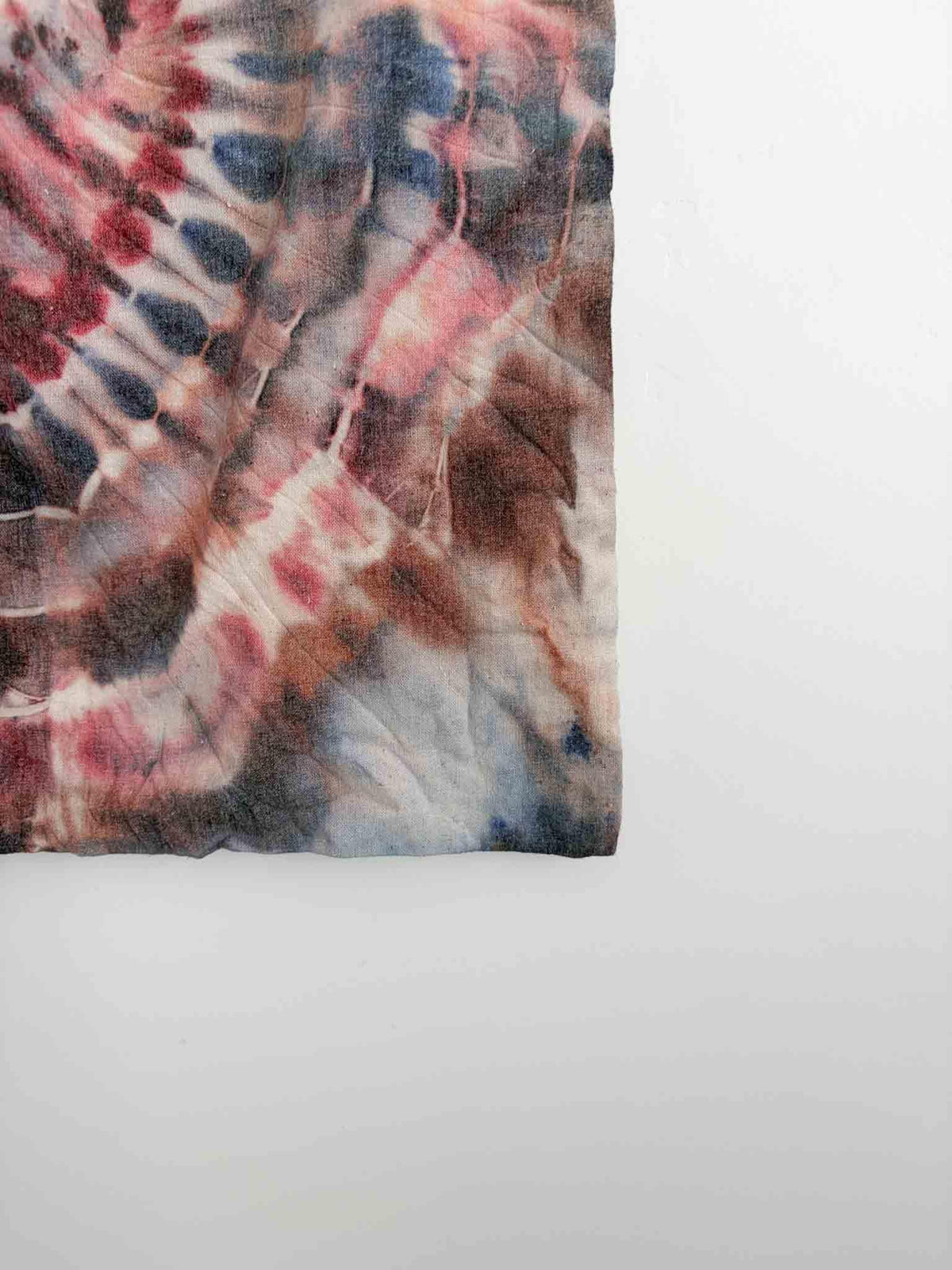 Close up of ice dye heart fold pattern on cotton canvas tote bag in rust and blush tones