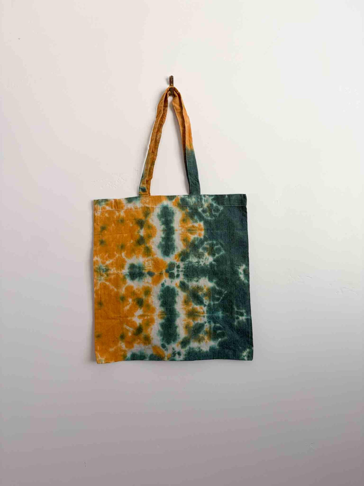 Mustard gold and forest green shibori tie dye tote bag hanging, 100% cotton canvas with handles