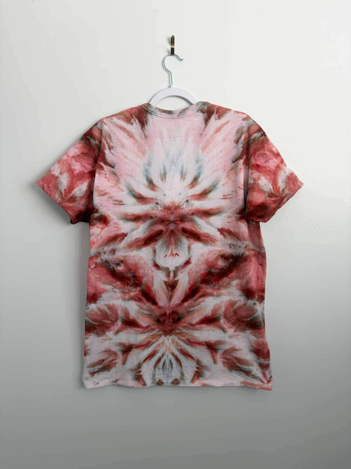 Rust red and pink ice dye v-neck shirt back view on hanger tie dye mandala pattern