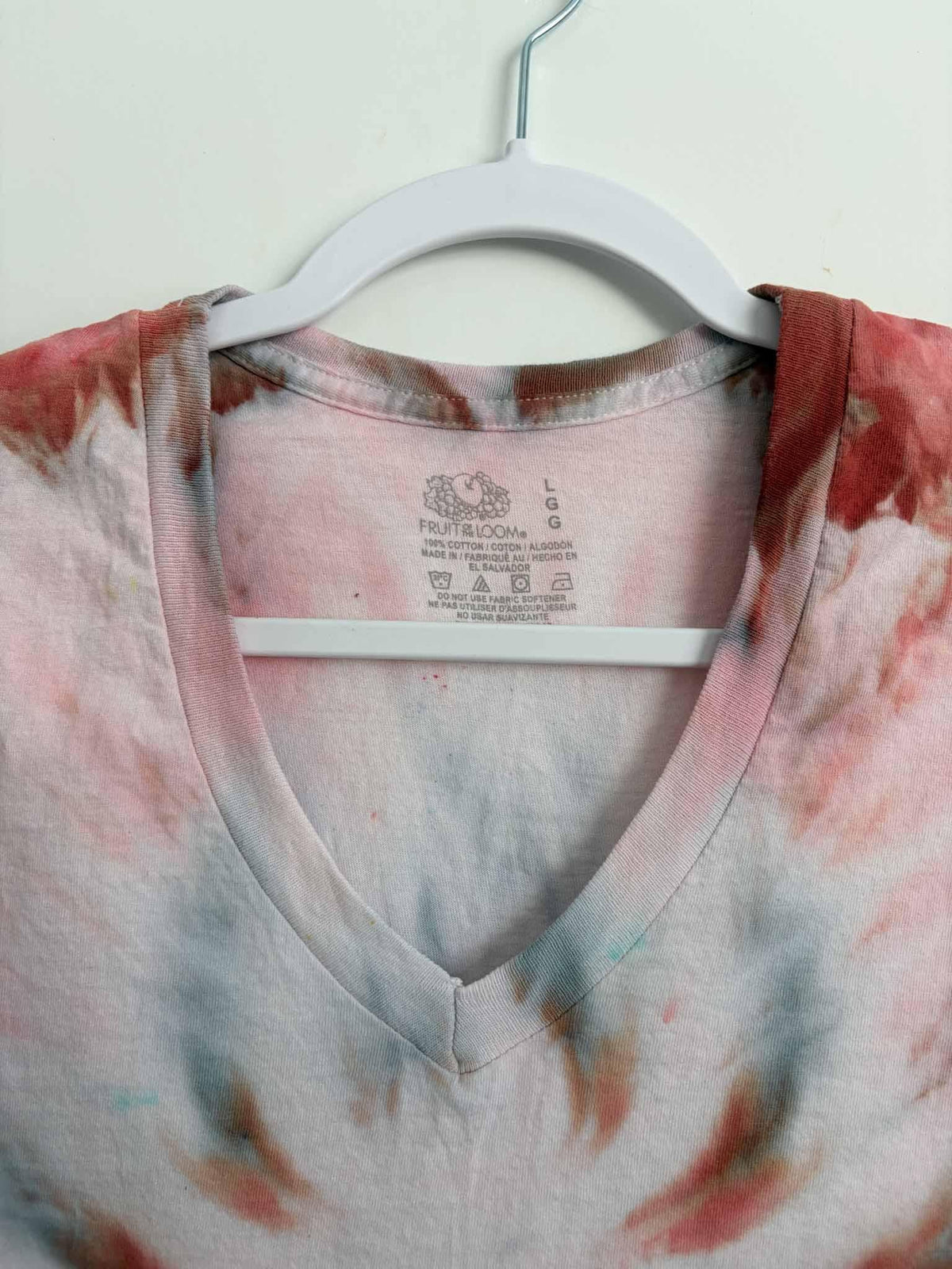 Fruit of the Loom tag inside pink and rust tie dye v-neck shirt size large