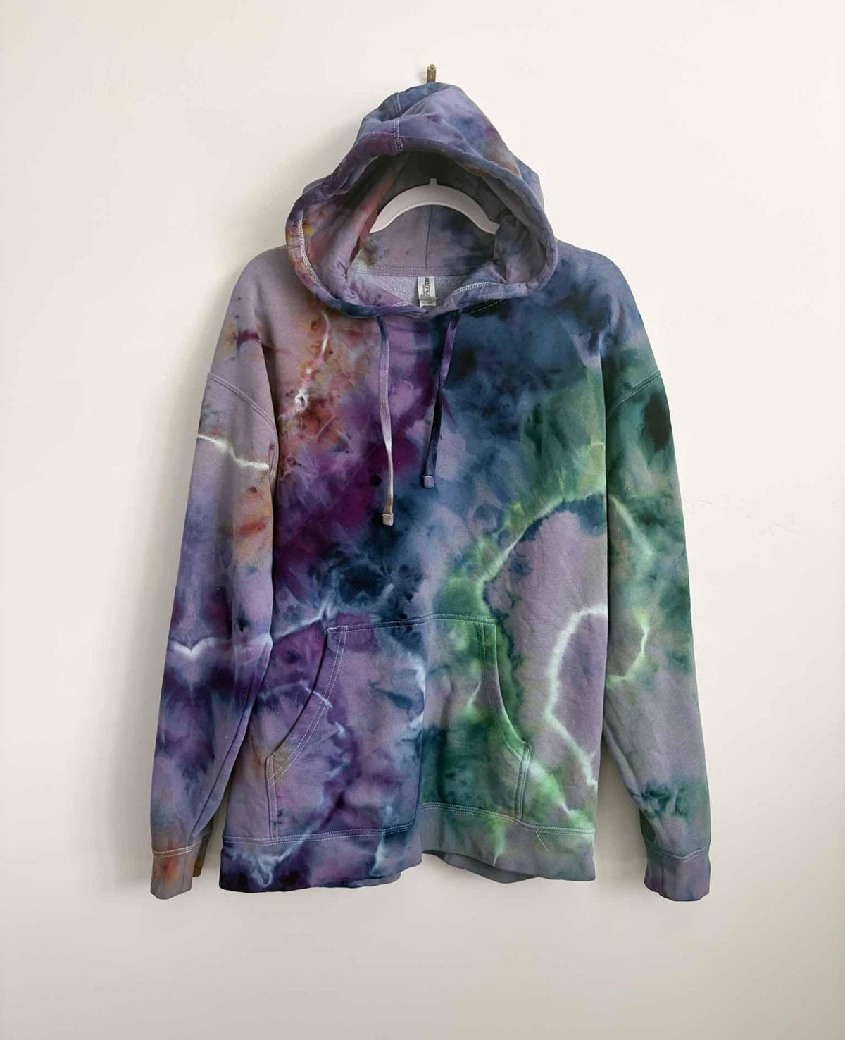 XL purple green and blue ice dye tie dye hoodie hanging, front view, handmade one of a kind