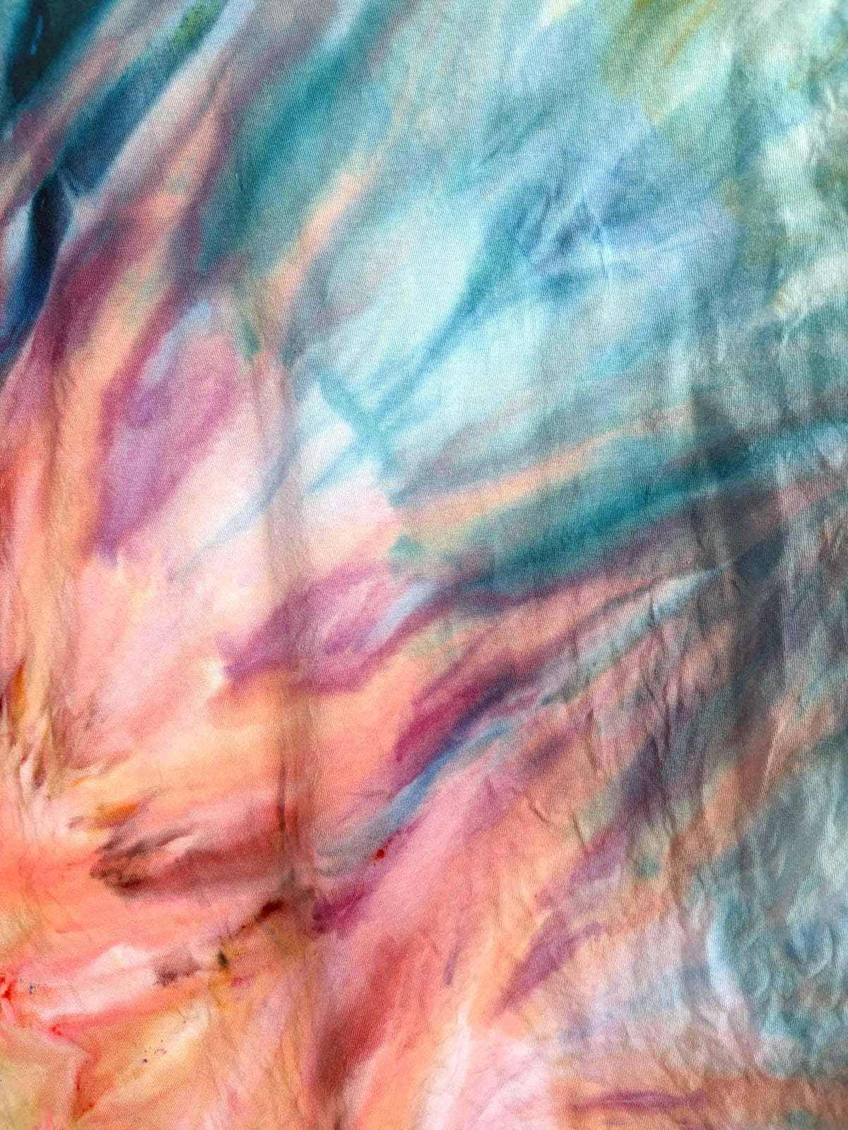 Close up of fern fold ice dye pattern on L sunset colorway tie dye tee