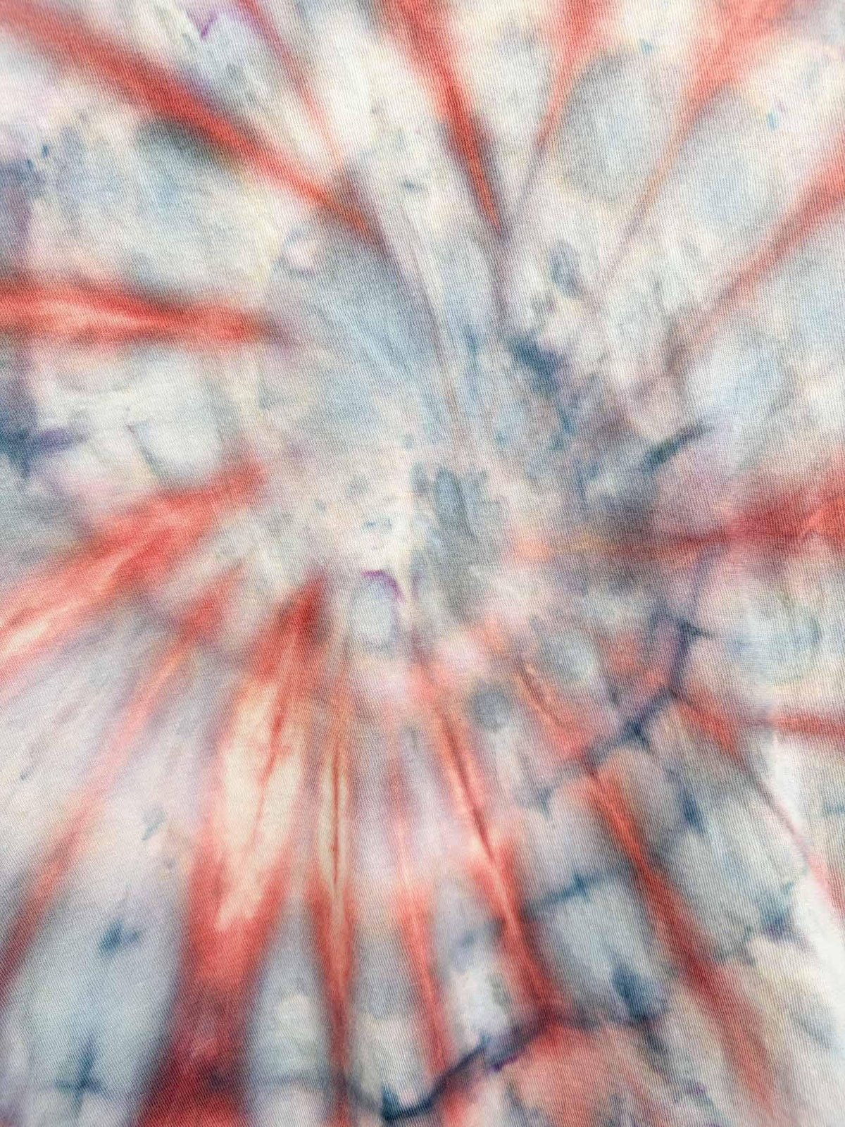 Close up of spiral tie dye pattern on red and gray tie dye tee