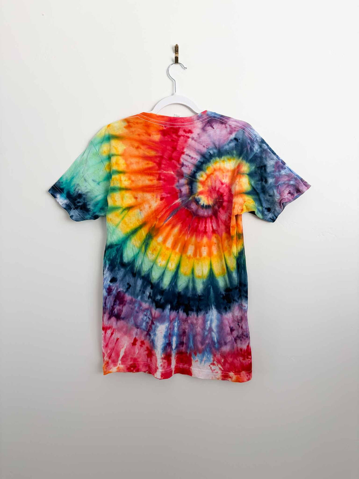 M rainbow spiral tie dye tee hanging, back view, handmade one of a kind