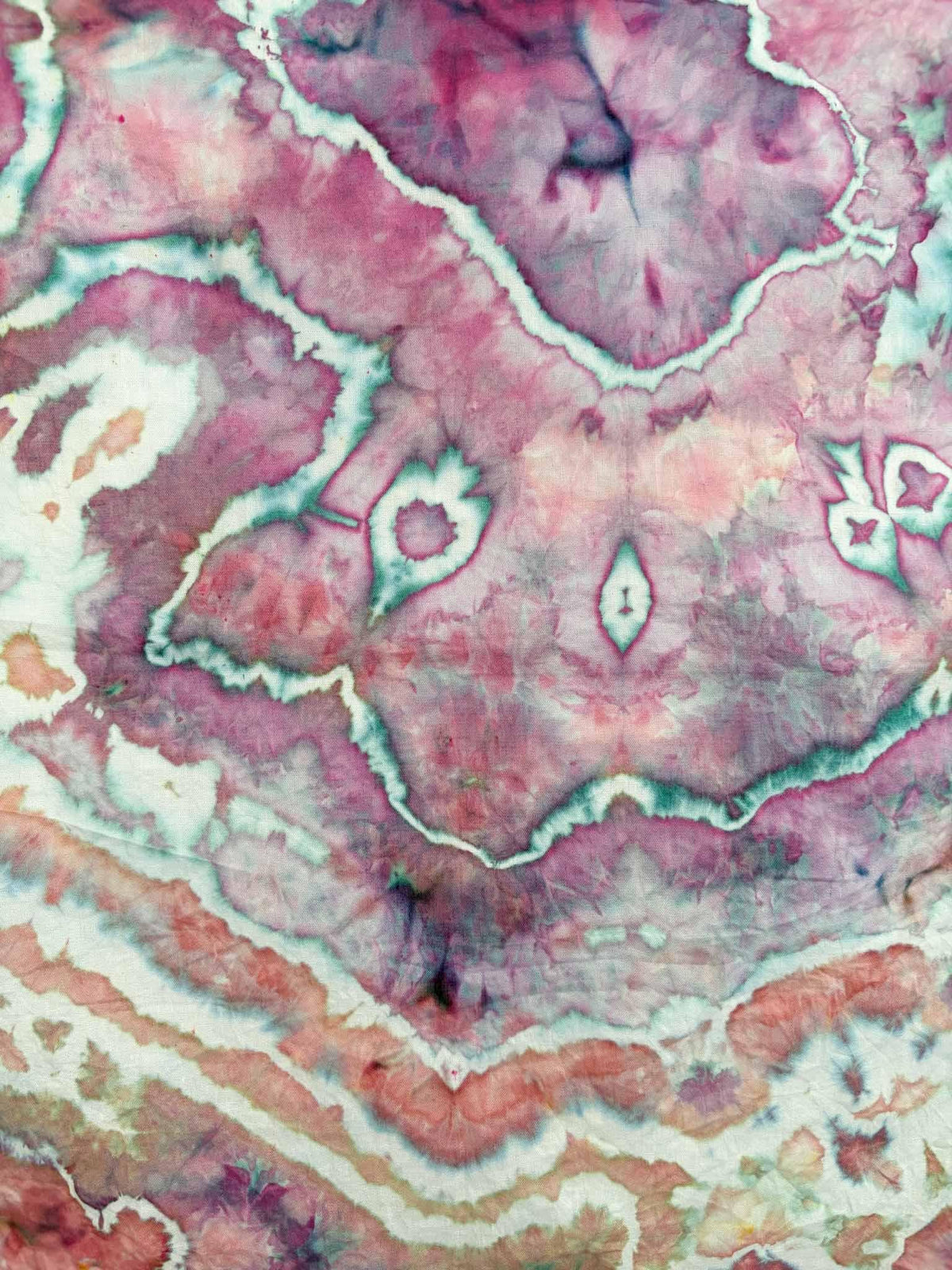 Close up center detail of hand dyed bandana showing pink magenta geometric geode motifs outlined in teal