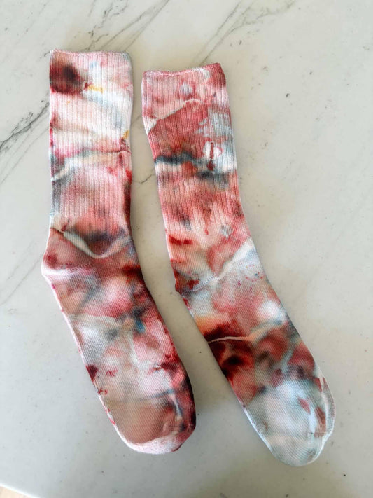 Pair of bamboo crew socks in Bloodmoon tie dye colorway laid flat