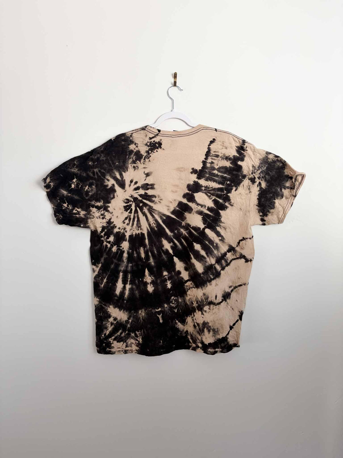 Back view of reverse tie dye spiral shirt in black and tan
