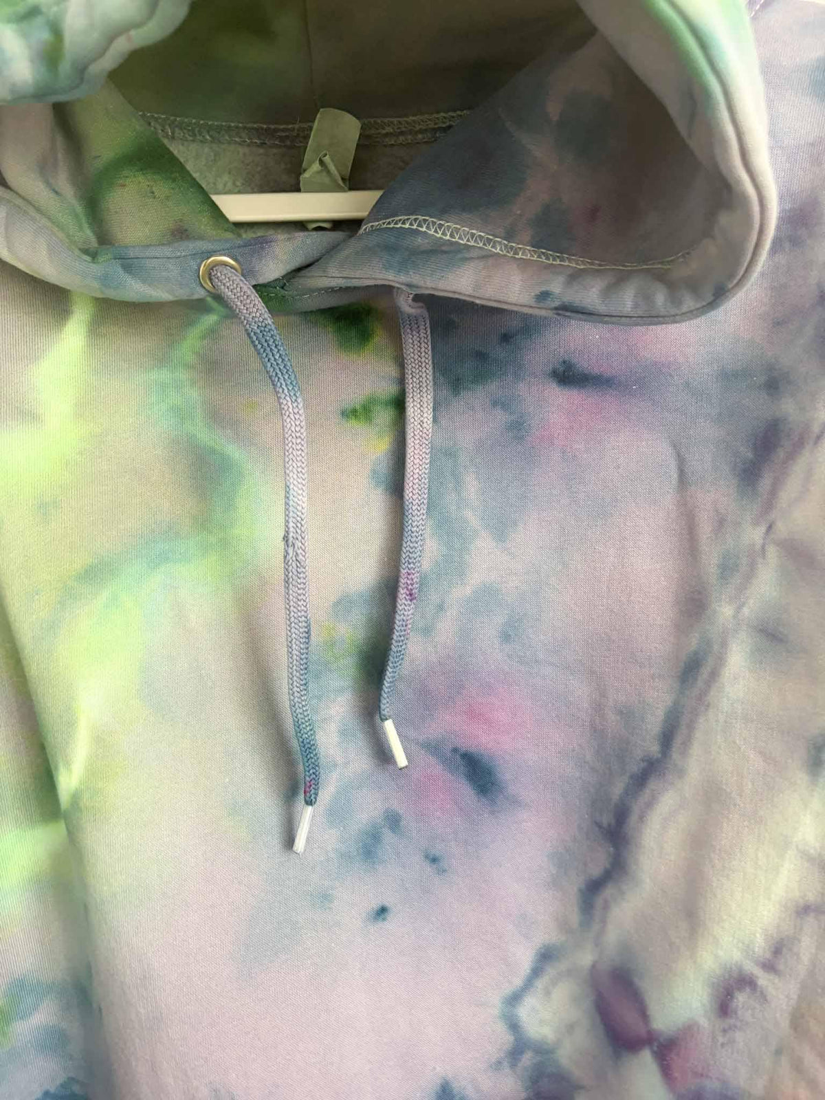 Close up of hood drawstring on XL purple green ice dye tie dye hoodie