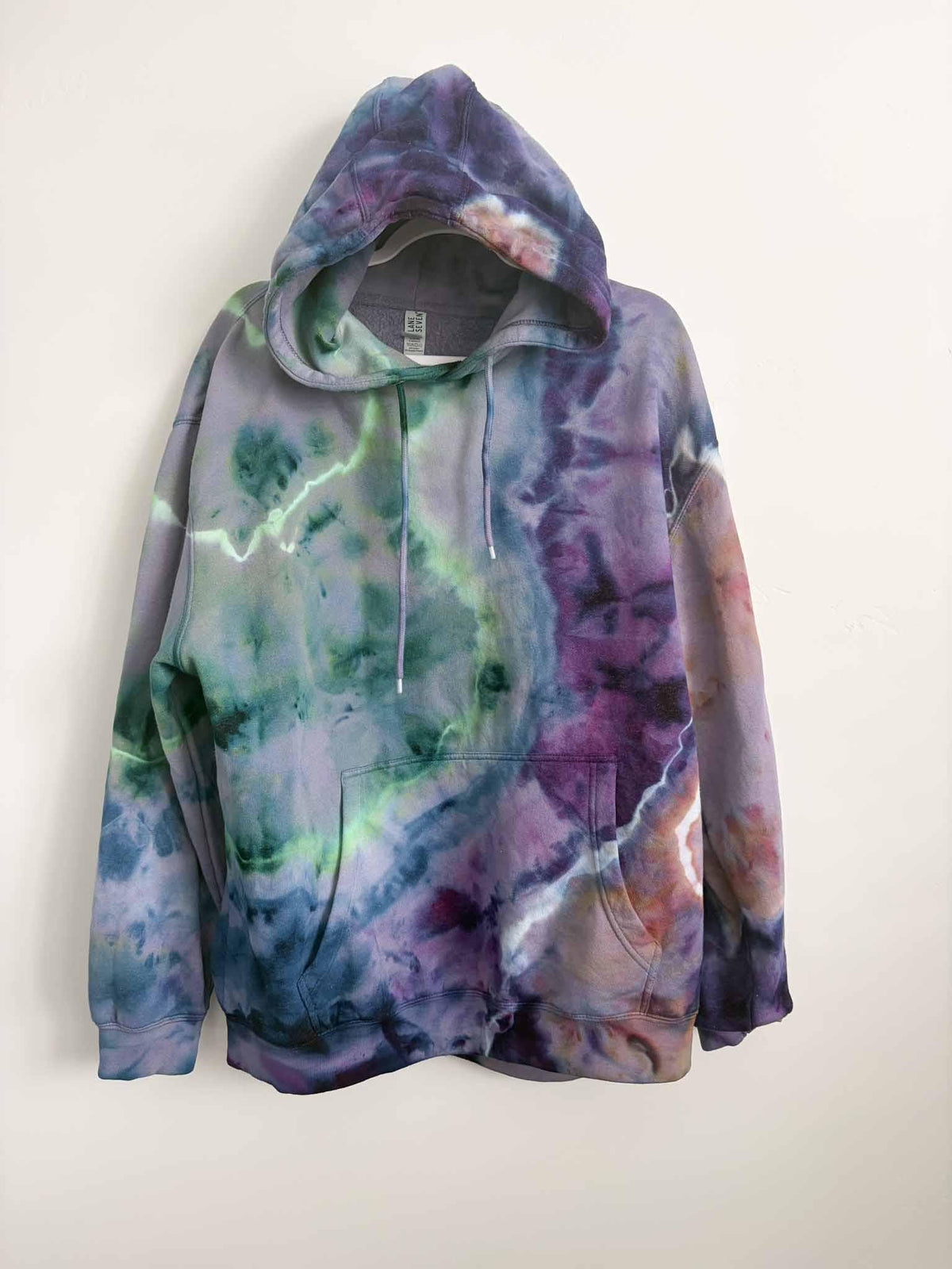 XL purple green and blue ice dye tie dye hoodie hanging, front view, handmade one of a kind