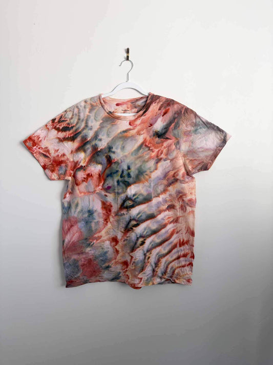 XL ice dyed t-shirt in rust, slate blue, and cream hanging on a white hanger against a white wall