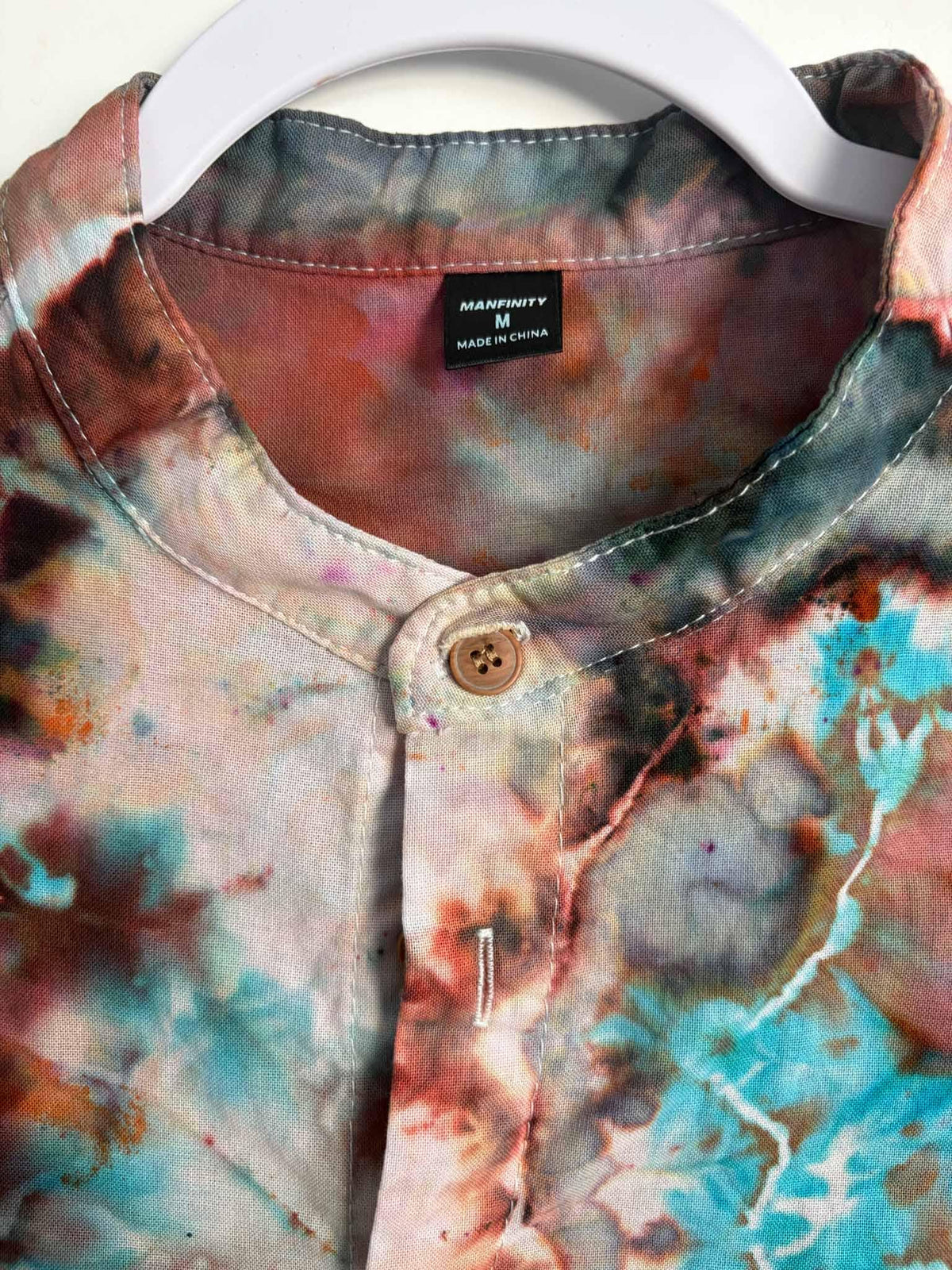 Manfinity size M tag inside a geode patterned tie dye button down shirt collar