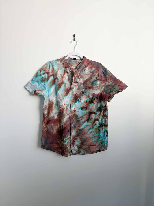 M ice dyed button down shirt in turquoise and rust roll fold pattern hanging on a white hanger