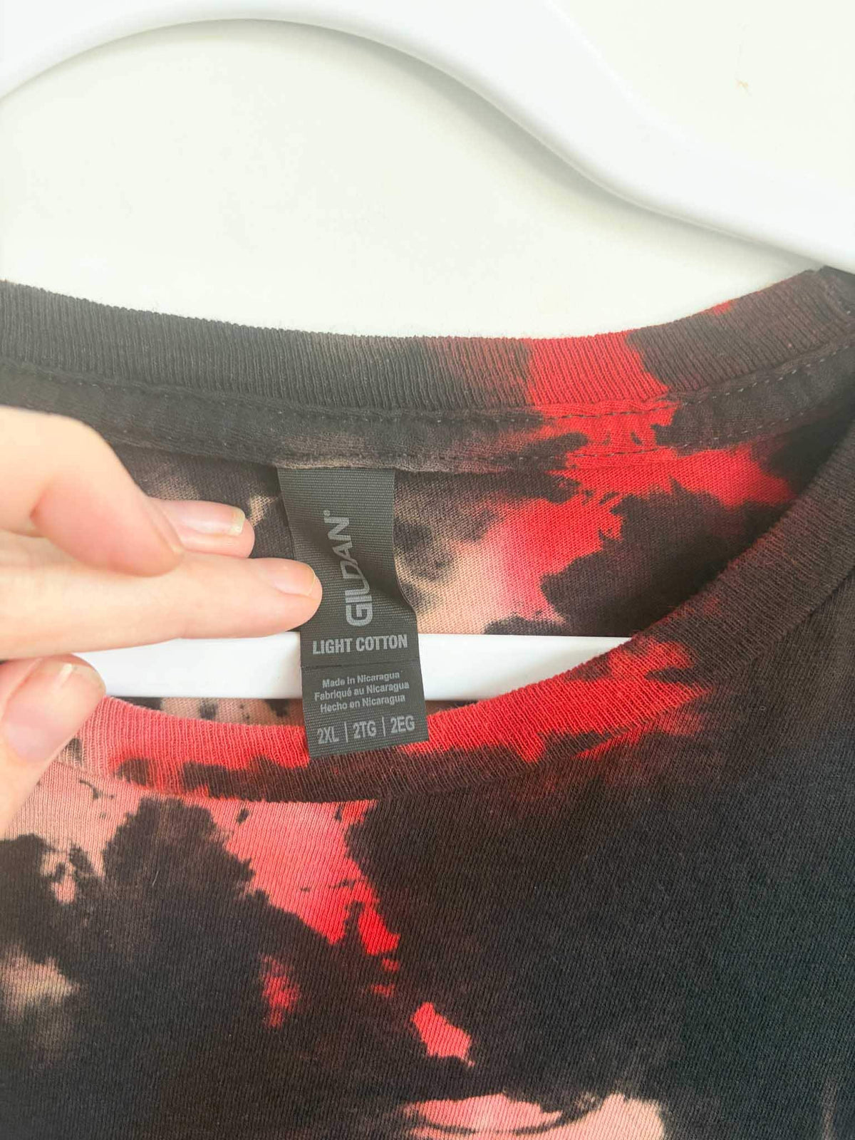 Close up of Gildan Light Cotton size 2XL tag on black and red shibori tie dye shirt