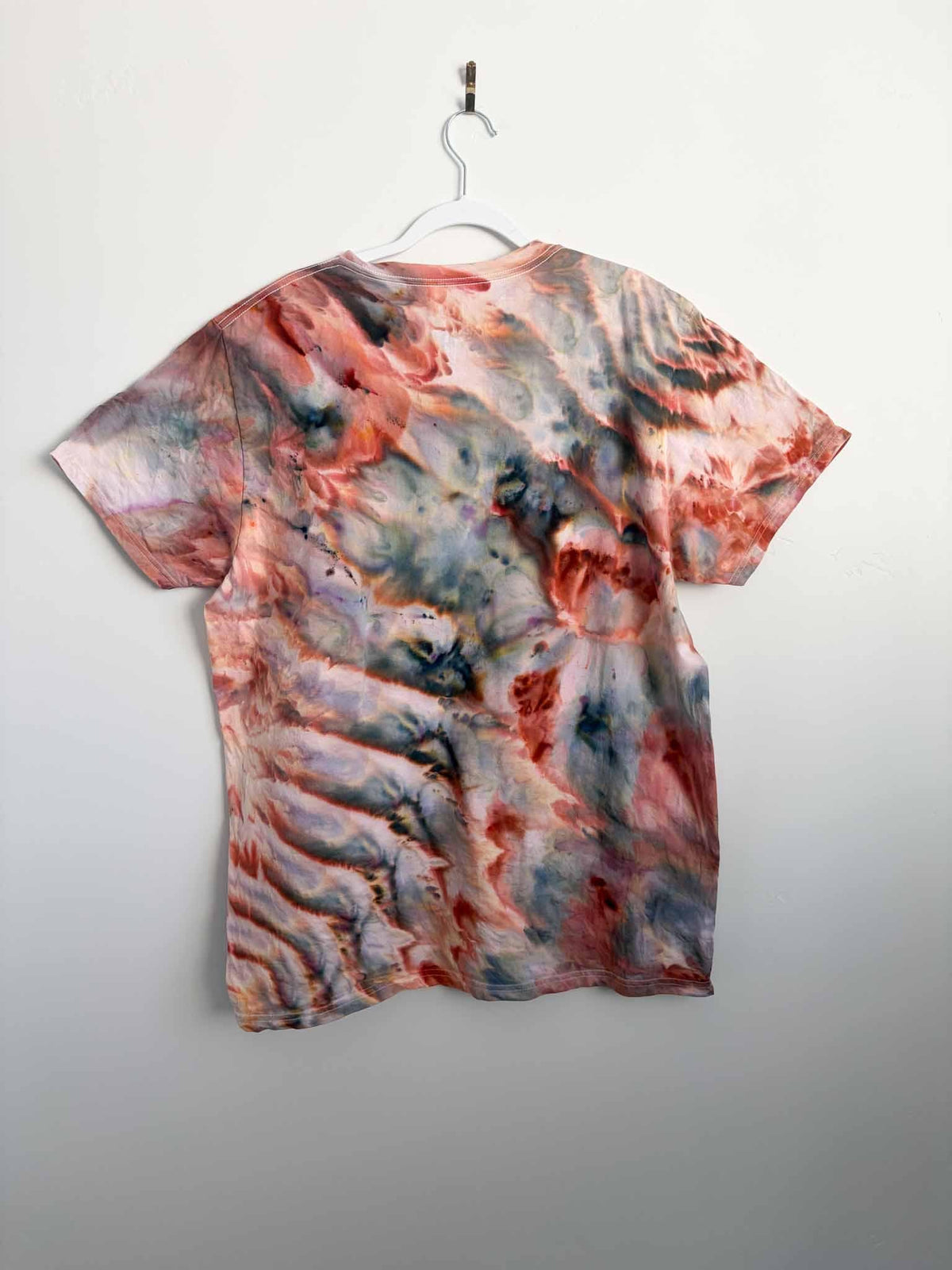Back view of XL ice dyed t-shirt showing double roll fold pattern in rust and slate blue